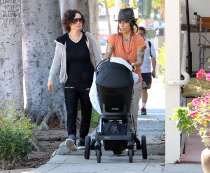 Sara Gilbert and wife Linda Perry take their newborn son Rhodes on a sunny stroll